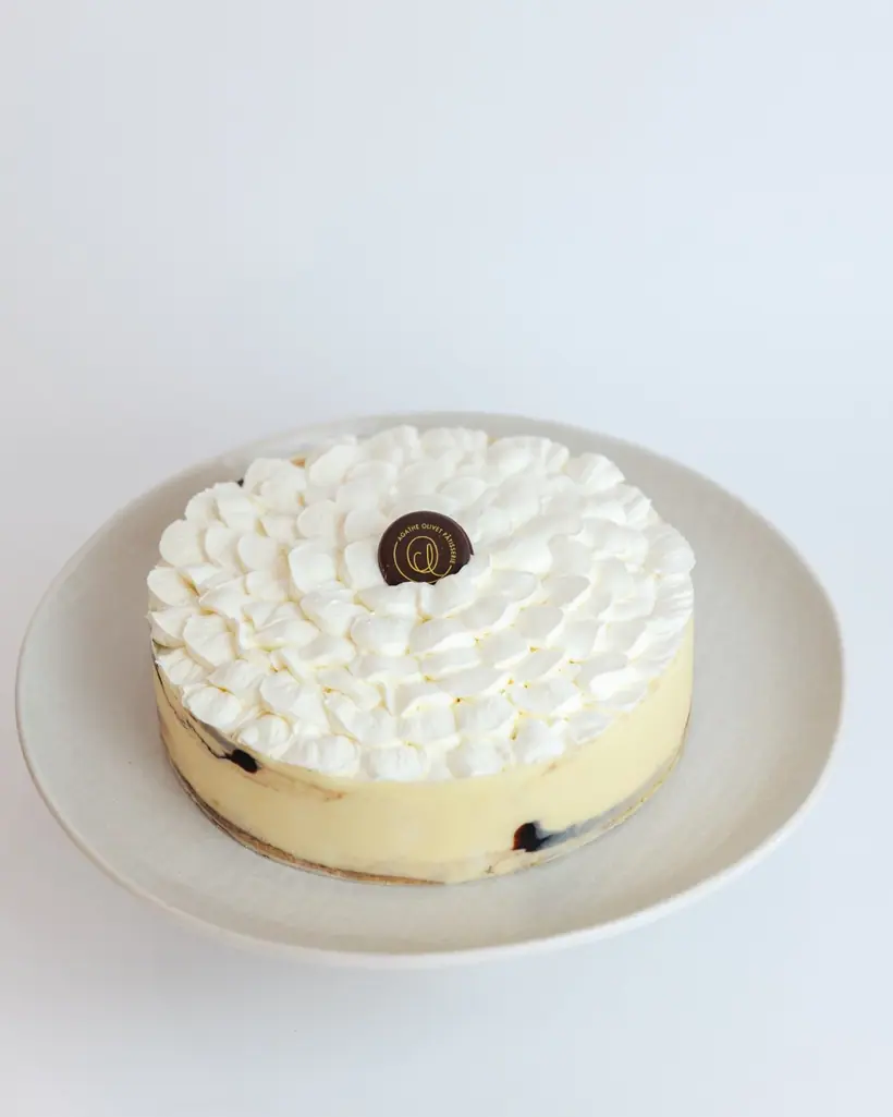 An entremets covered with Chantilly piped into petals, on a plate
