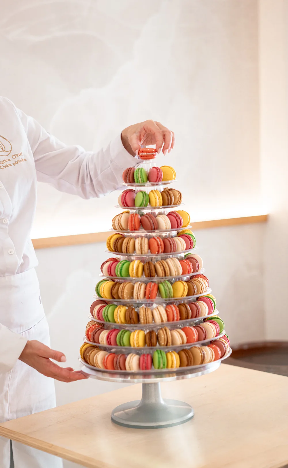 Agathe Olivet dressant une pyramide de macarons multicolores